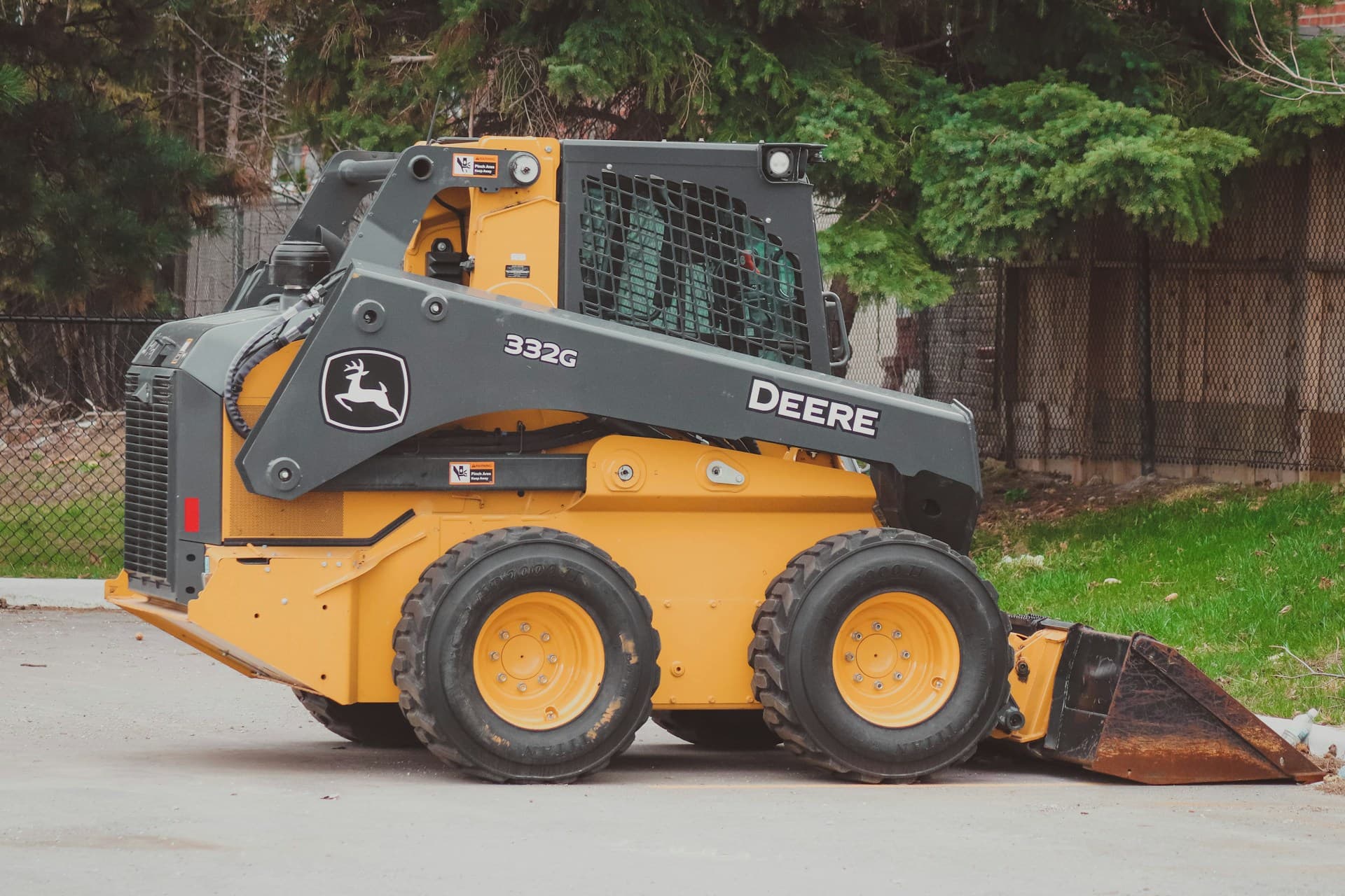 Yellow John Deere skid-steer loader with bucket parked outdoors