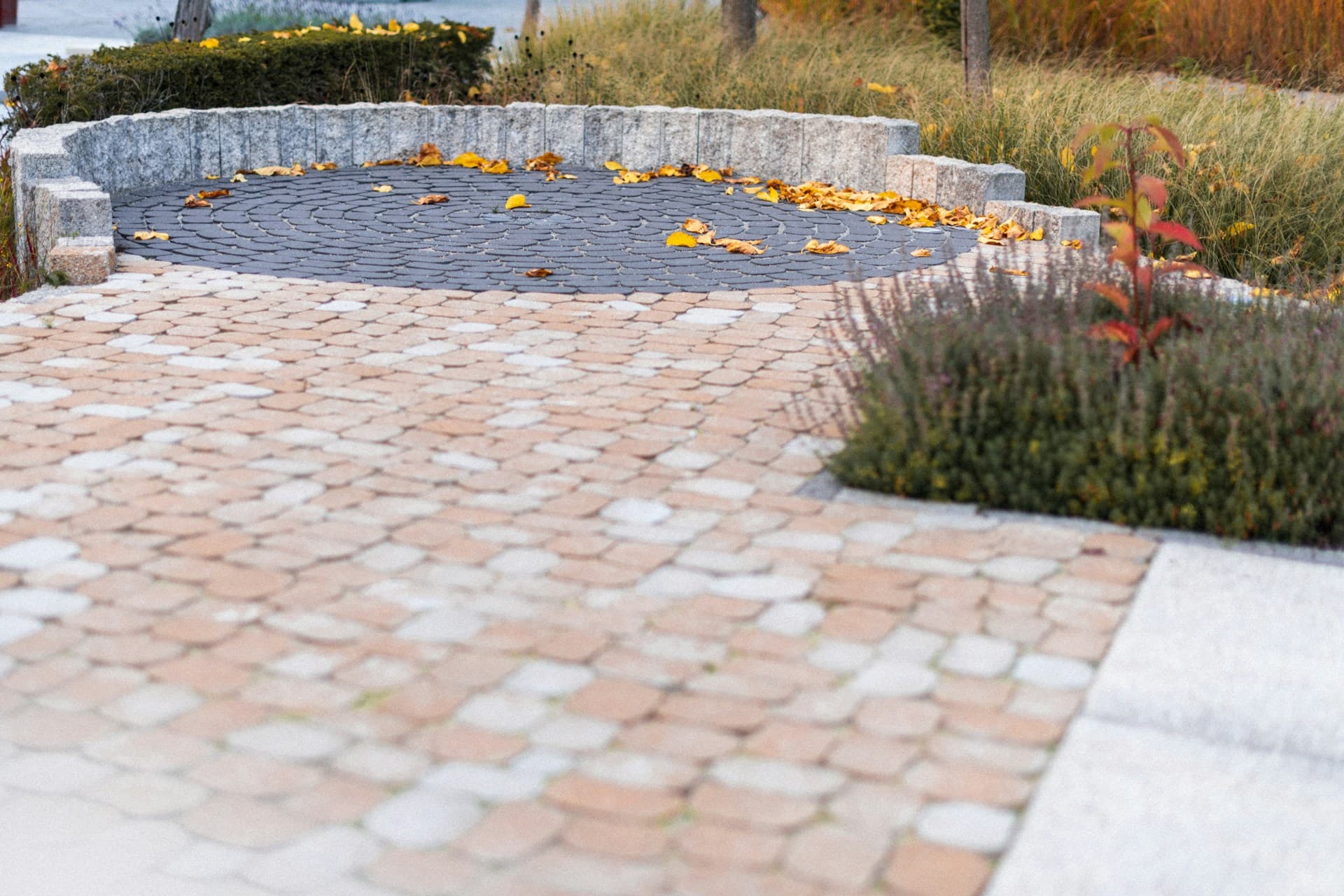 Cobblestone and circular paved courtyard with garden border and stone edging